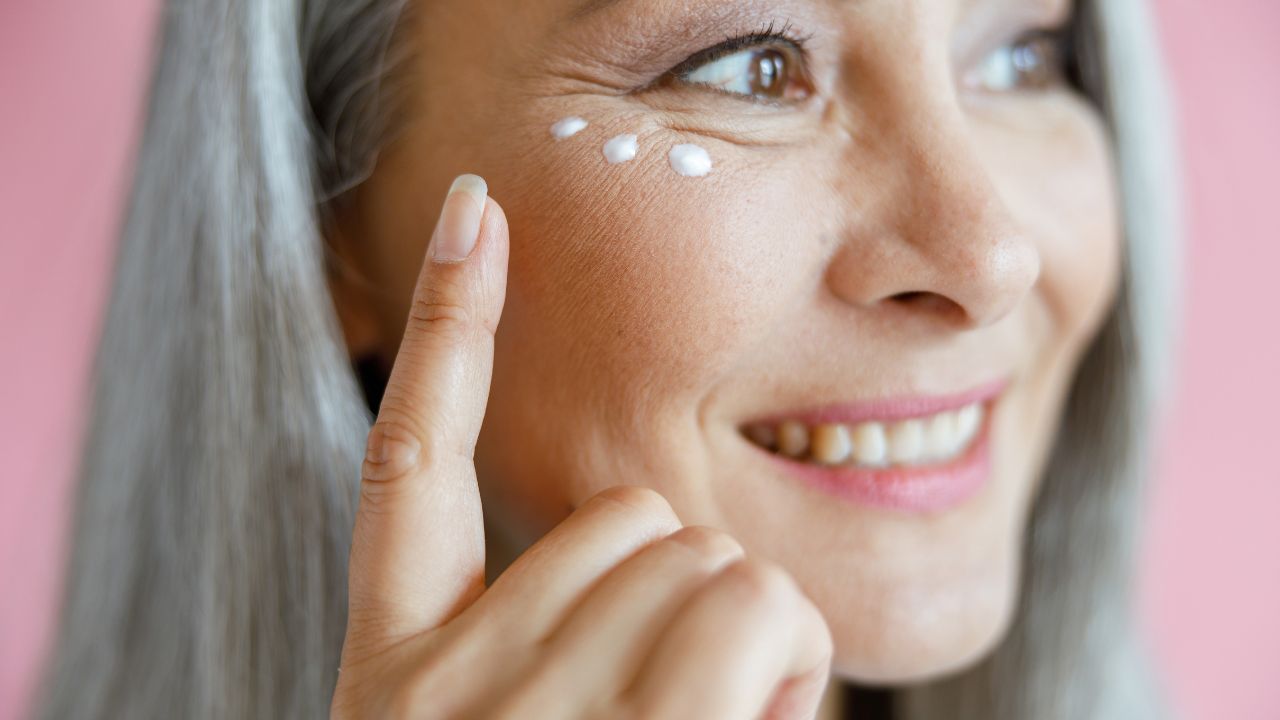 woman applying cream under eye