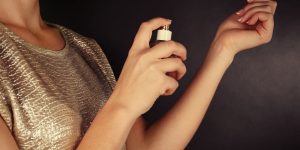 woman testing perfume on wrist